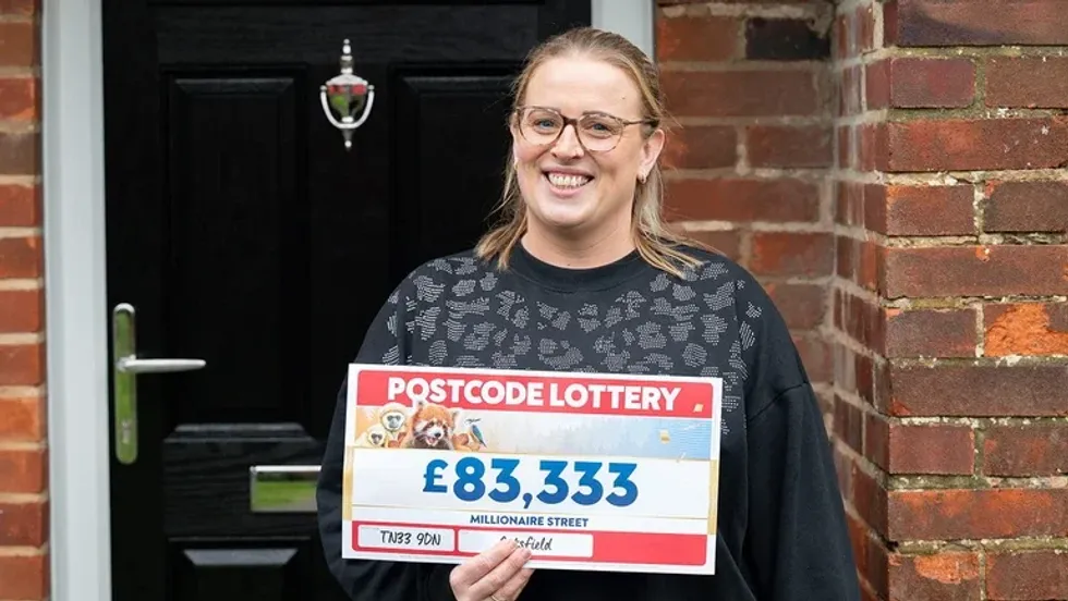 Steph Godfrey holding postcode lottery cheque