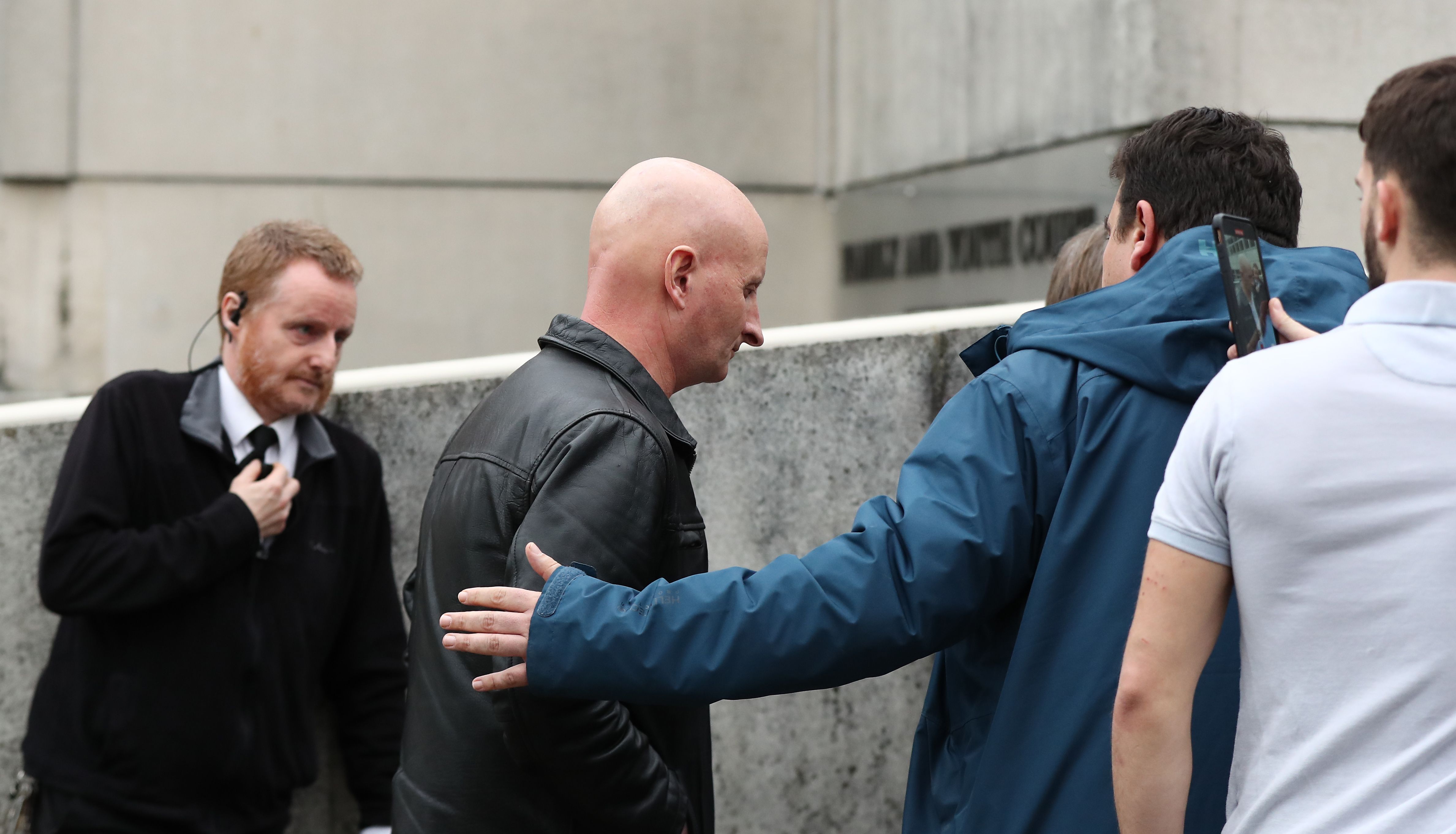 Steve Bouquet (centre) is escorted away from Brighton Magistrates Court after appearing on 16 counts of criminal damage over attacks in Brighton on cats between October 2018 and June 2019.