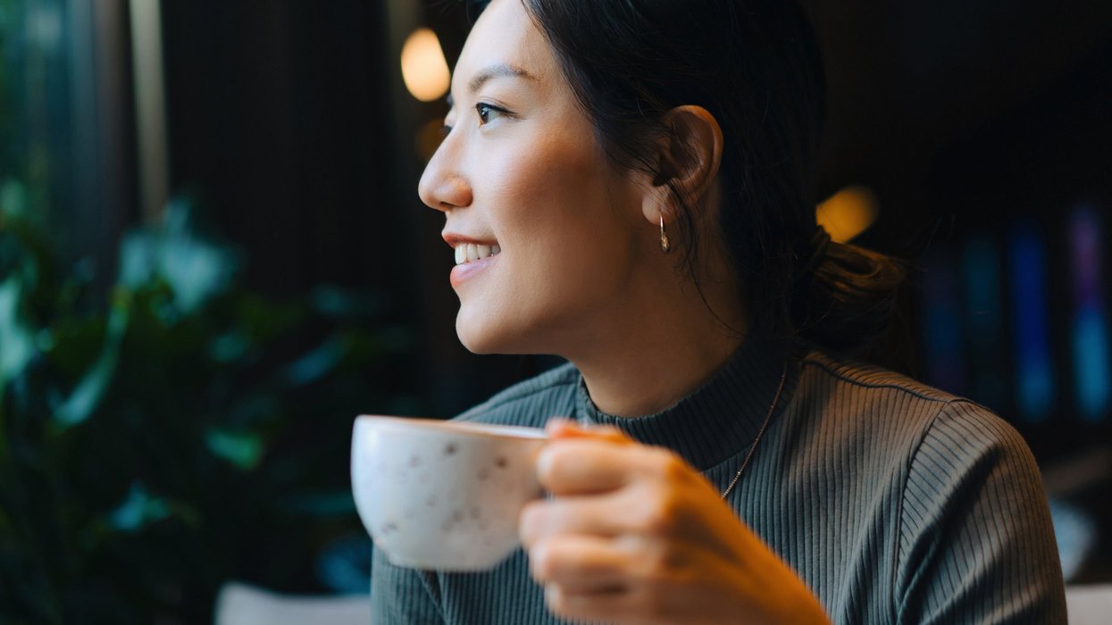 Stock image of a woman holding a cup of coffee