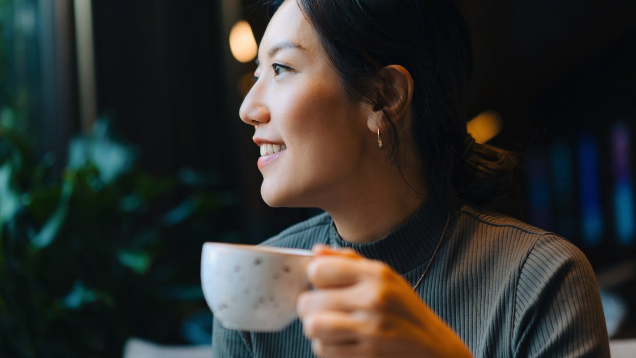 Stock image of a woman holding a cup of coffee