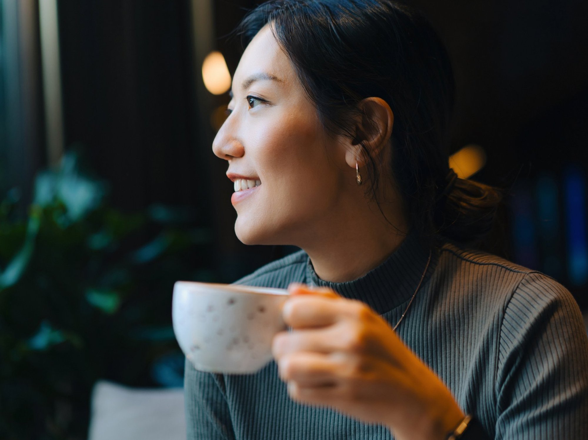 Stock image of a woman holding a cup of coffee