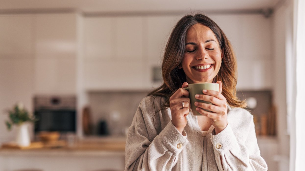 Stock image of a woman holding a cup of coffee