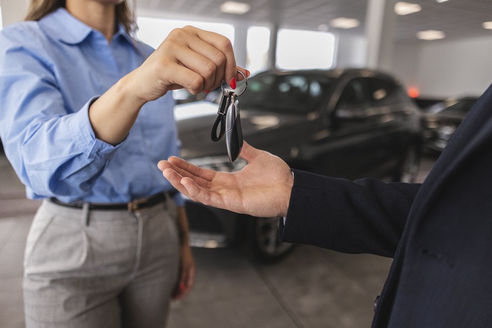 Stock image of car keys being handed over to recipient