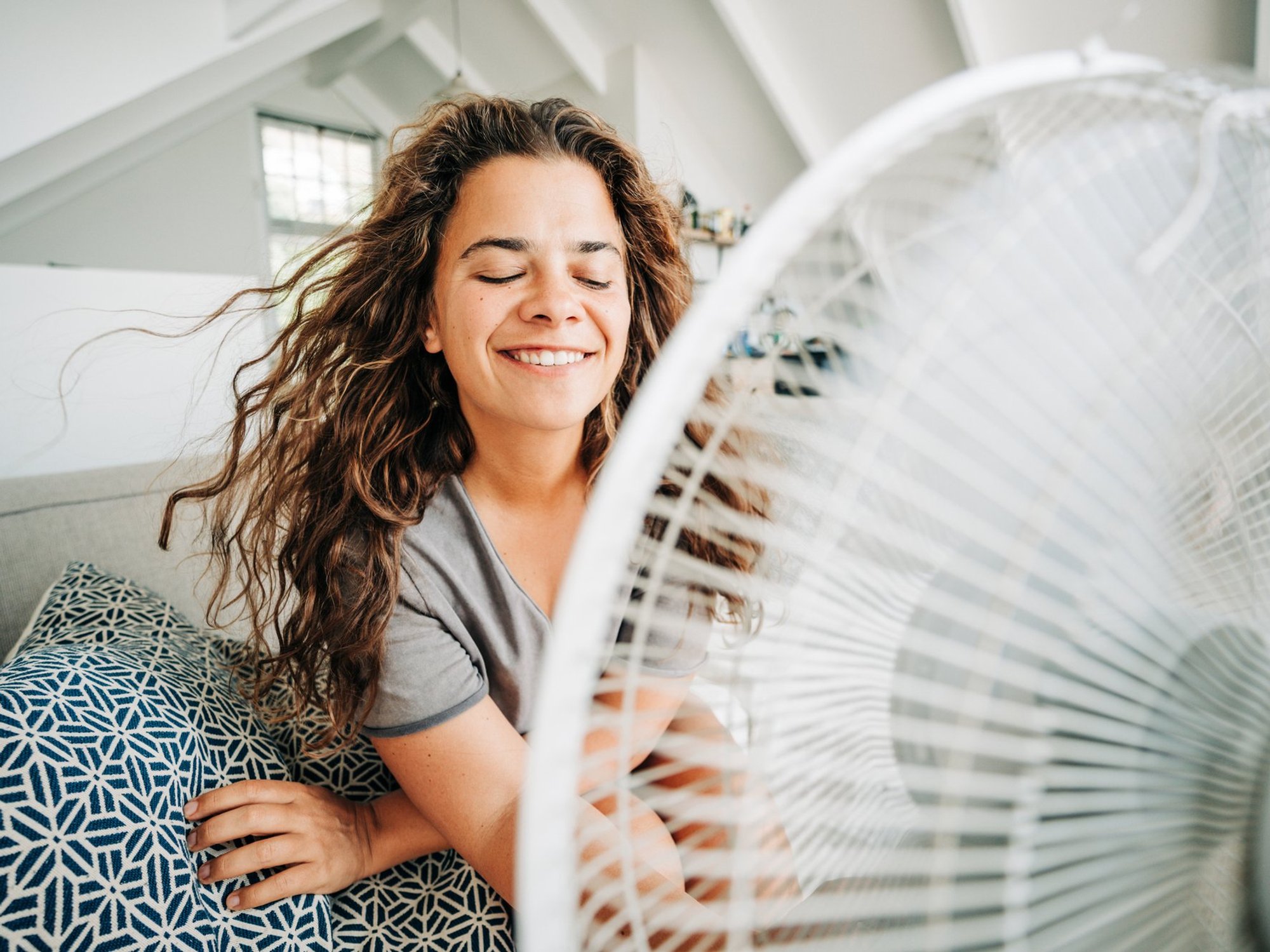 Stock image of woman sitting in front of a fan