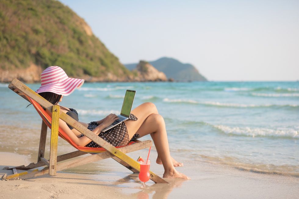 Stock image of woman working from beach
