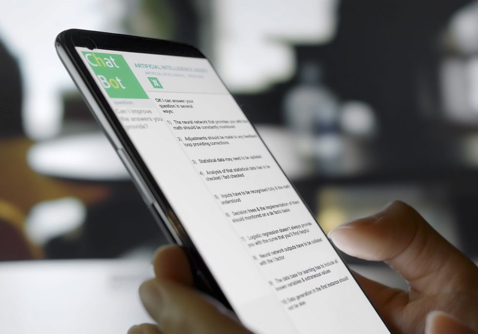 Stock image showing a smartphone being used in an open plan office