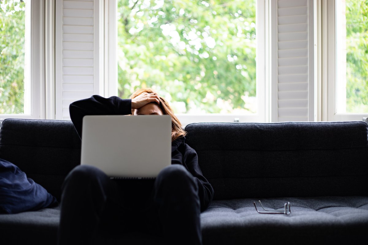 Stressed young woman looks at laptop