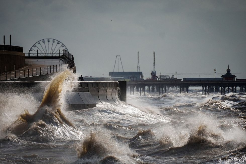 Strong winds and a high tide create large waves that hit the seawall on Blackpool Promenade