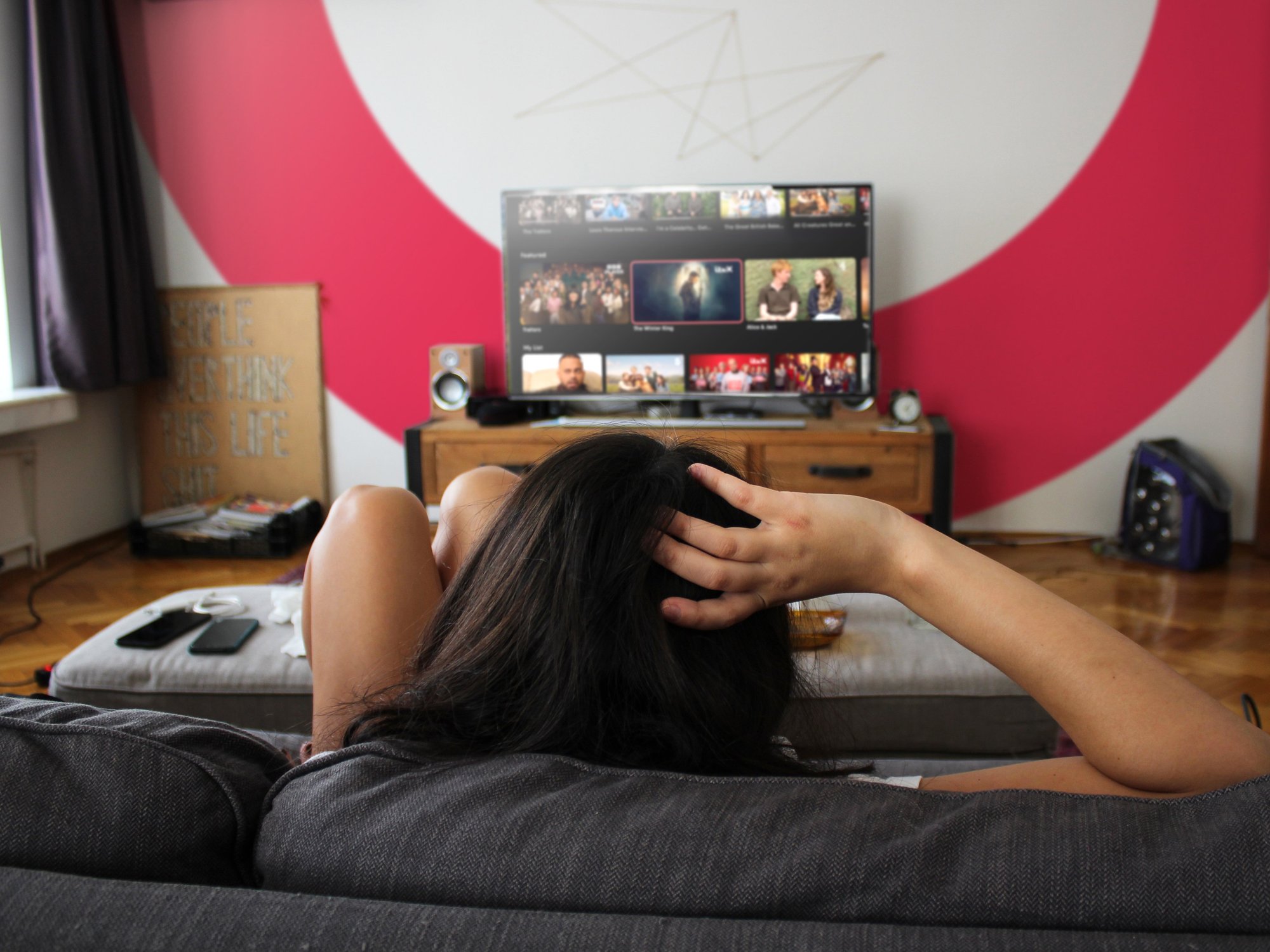 student relaxes on a sofa watching Freely channels on the television