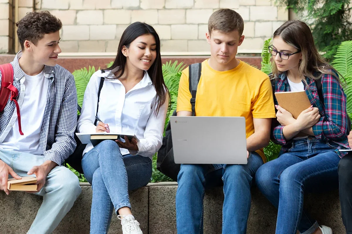 students gather around a chromebook go laptop