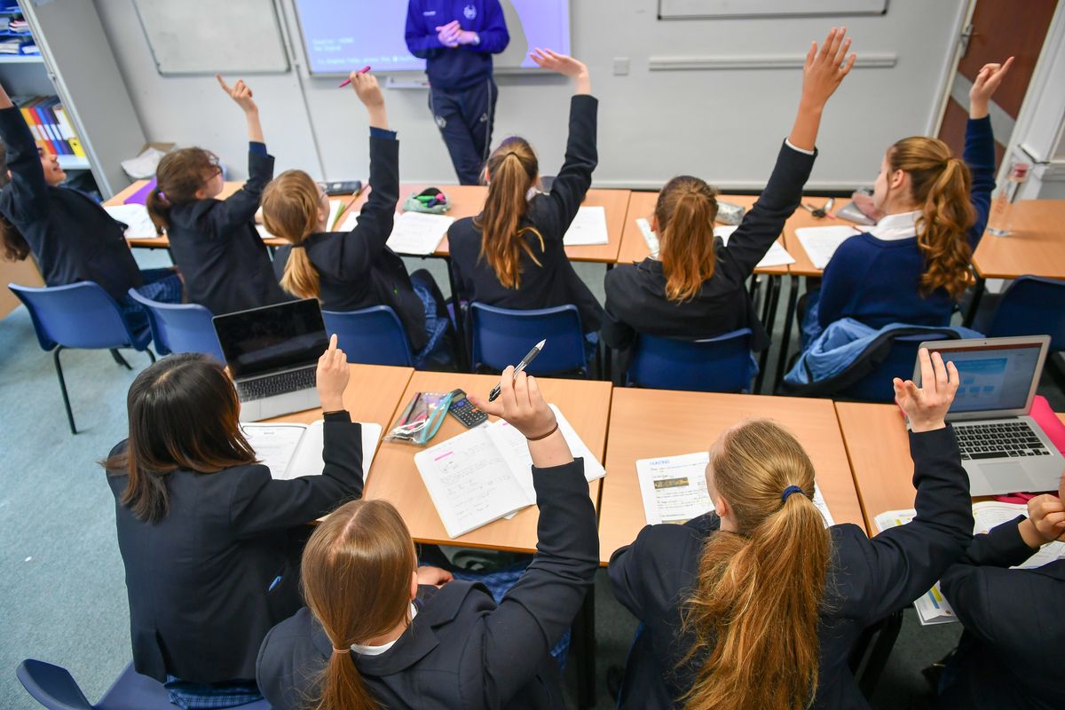 Students raise their hands in class at Royal High School Bath