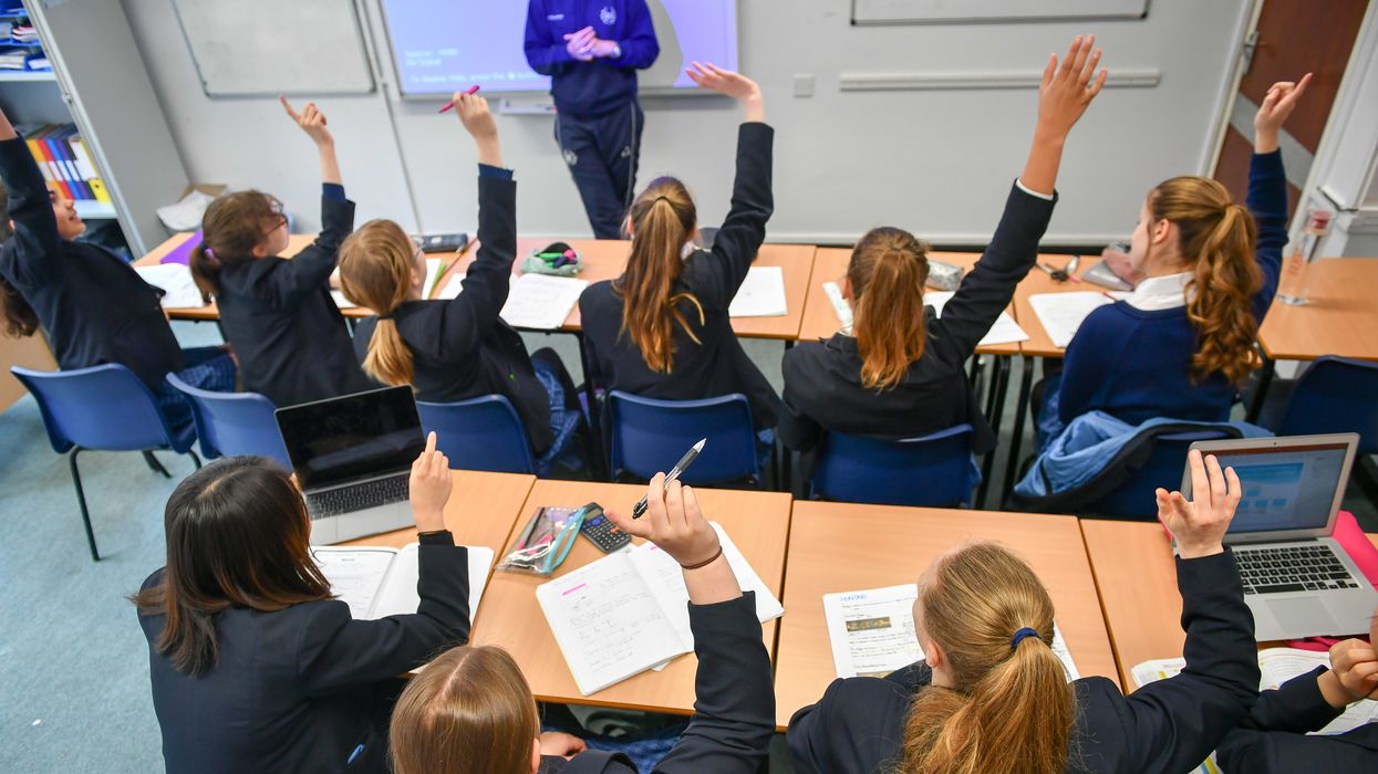 Students raise their hands in class at Royal High School Bath