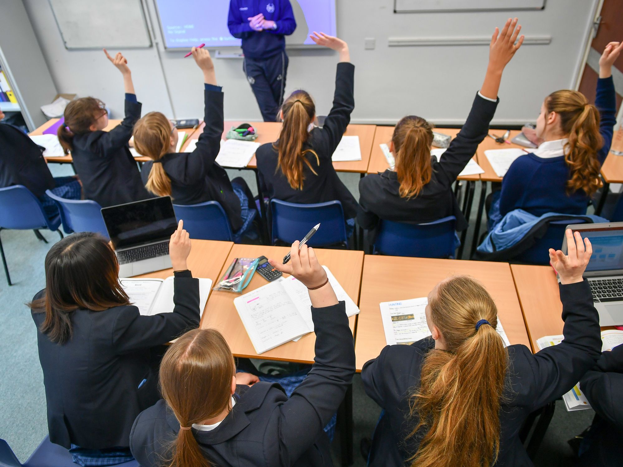 Students raise their hands in class at Royal High School Bath