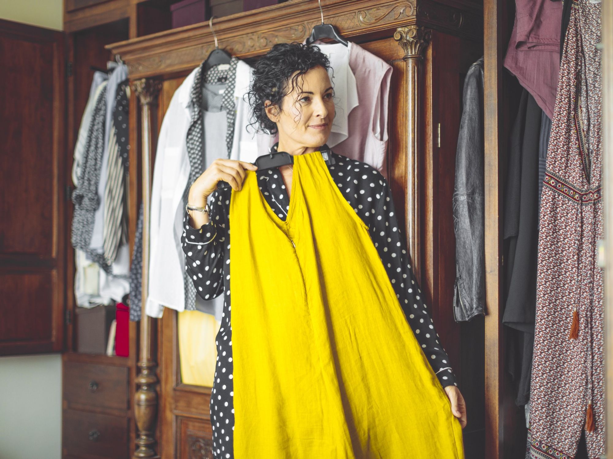 Stylish middle-aged woman trying on clothes