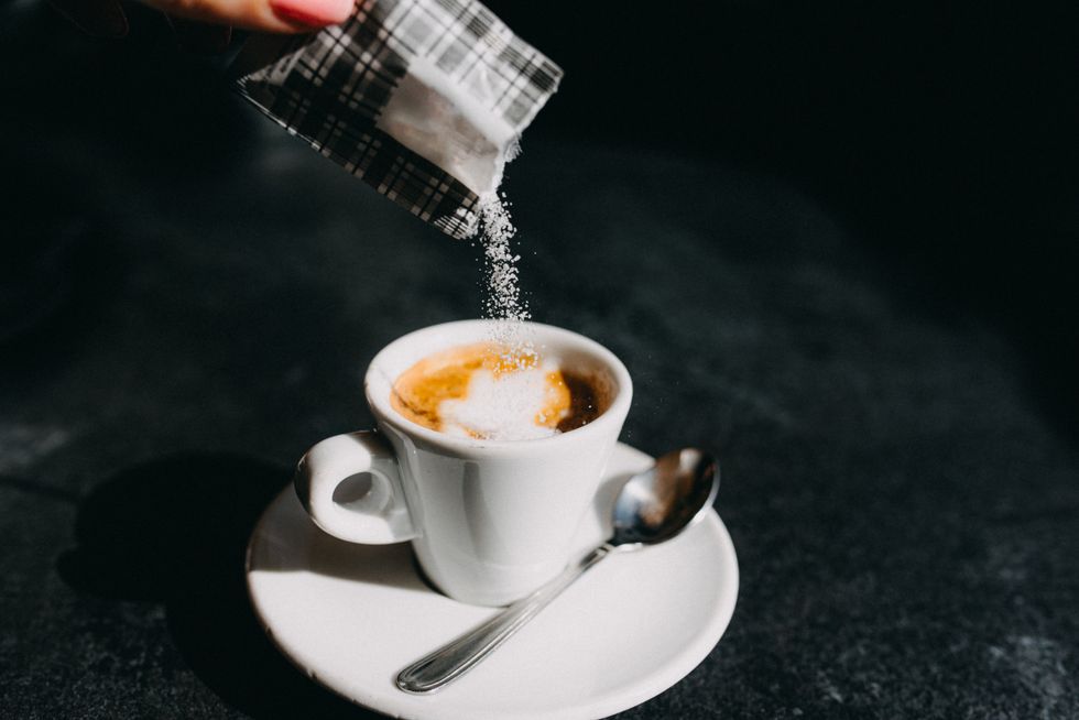SUGAR BEING POURED INTO COFFEE