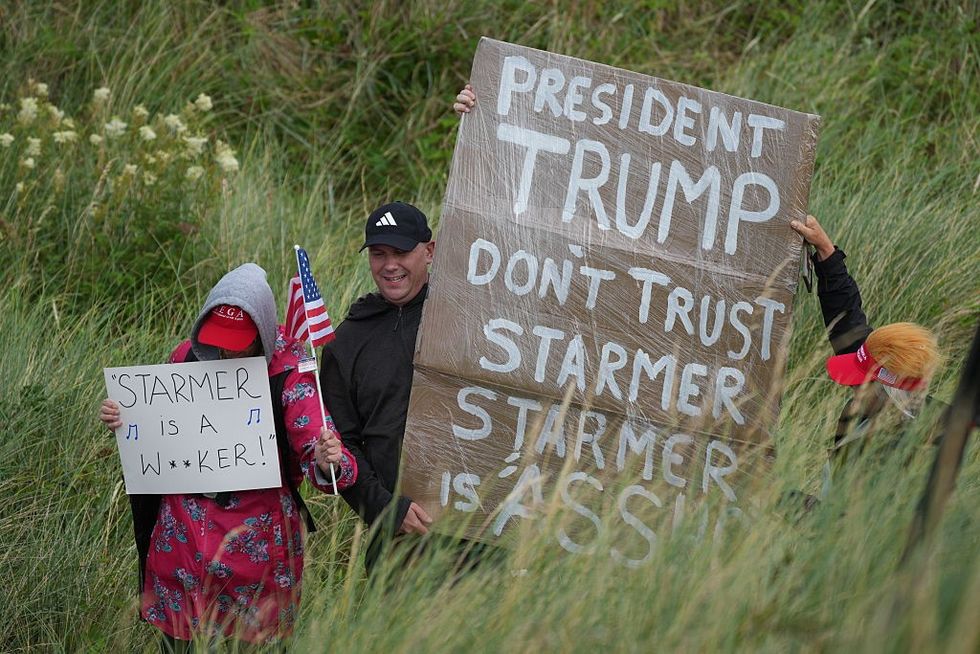 Zastánce Trumpa, který drží znamení, které mu říkalo, aby nevěřil Starmerovi