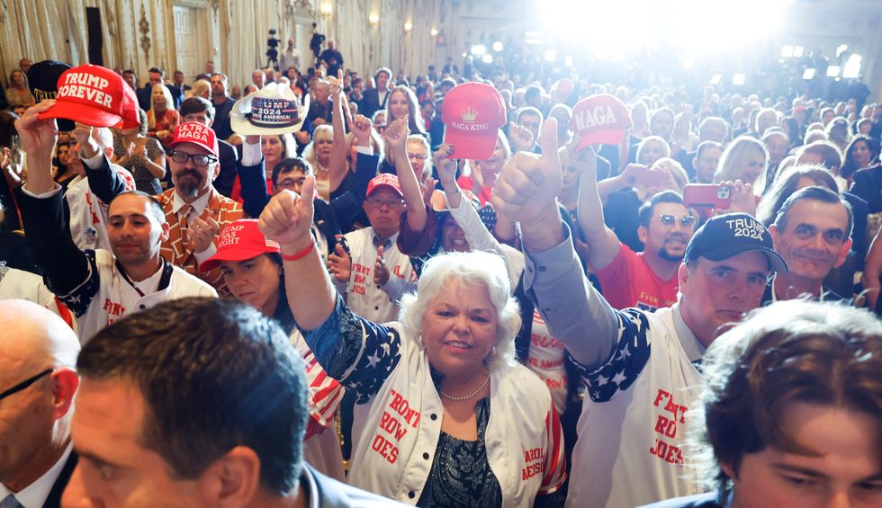 Supporters of former U.S. President Donald Trump holding up hats with slogans like %22MAGA King%22 and %22Trump Forever%22 cheer as he announces that he will once again run for U.S. president in 2024.