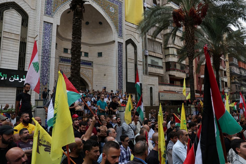 Supporters of Lebanon's Hezbollah carry flags during a rally to express solidarity with the Palestinians