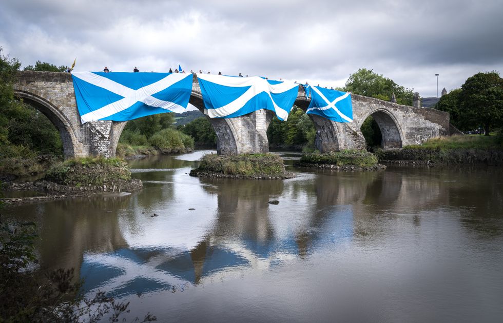 Supporters of Scottish independence hang huge Saltire flags over the Auld Brig