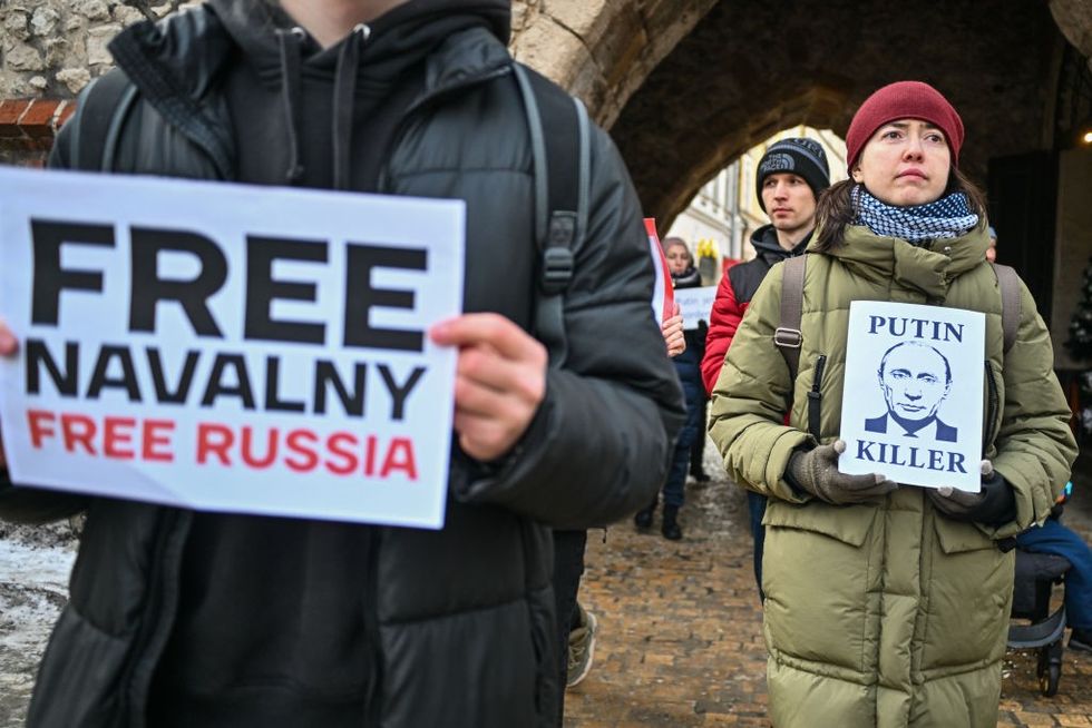 Supporters of the Russian opposition leader, Alexei Navalny hold banners and shout slogans during a protest demanding his release from prison in Krakow, Poland