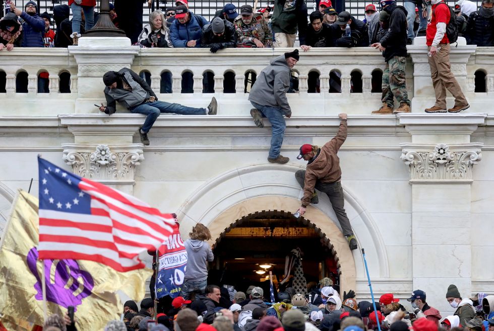 Supporters of U.S. President Donald Trump fight with members of law enforcement at a door they broke open as they storm the U.S. Capitol Building in Washington.