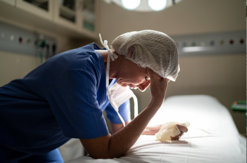 Surgeon holding her head