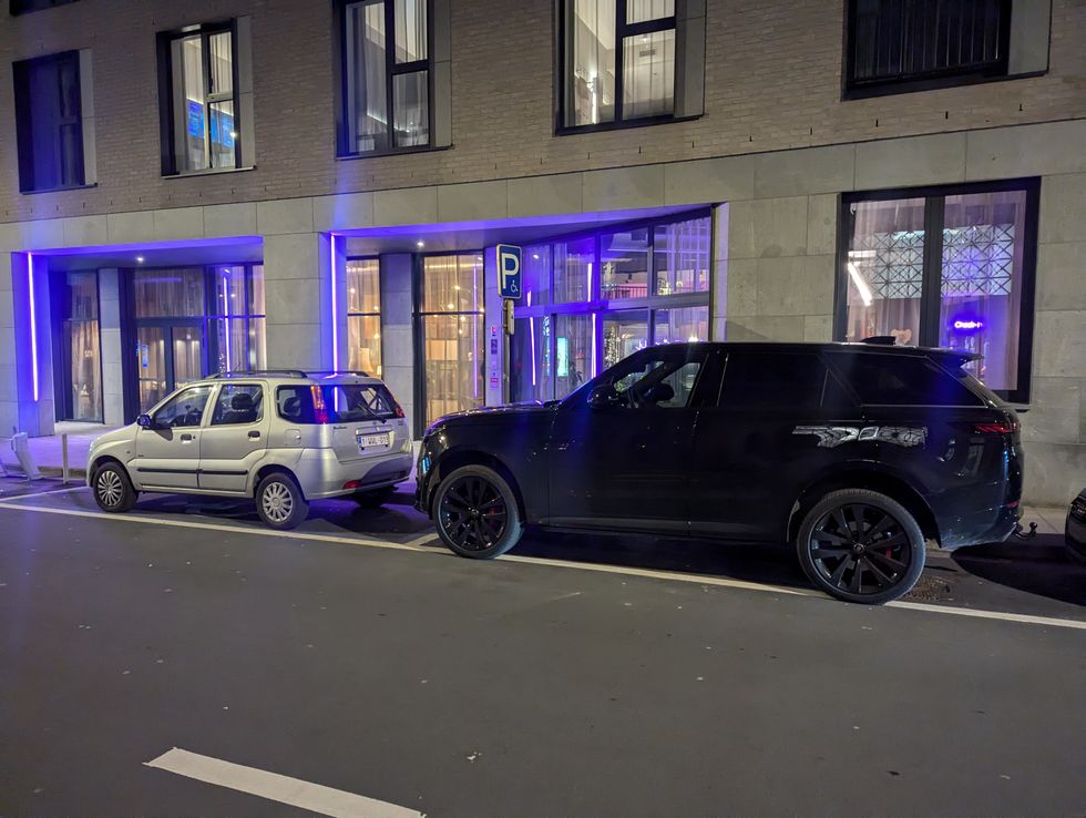 SUVs parked outside of parking space line