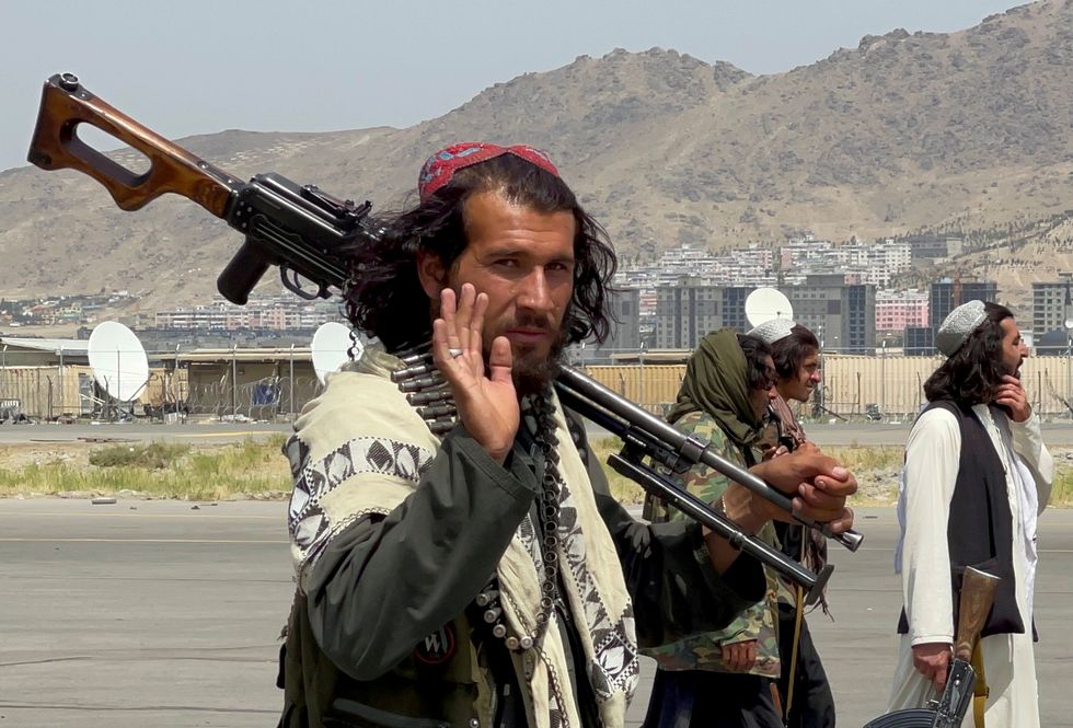 Taliban forces patrol at a Kabul airport runway