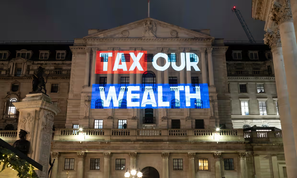 "Tax our wealth" projected onto building
