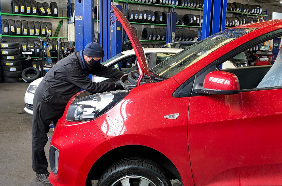 Technician performing an MOT test on a car