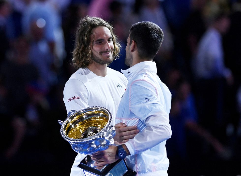 Tennis - Australian Open - Men's Singles Final - Melbourne Park, Melbourne, Australia - January 29, 2023 Winner, Serbia's Novak Djokovic hugs runner-up, Greece's Stefanos Tsitsipas as they hold their respective trophies after their final match REUTERS/Jaimi Joy TPX IMAGES OF THE DAY