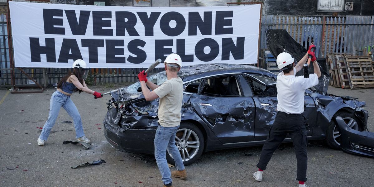 NextImg:Tesla critics smash electric car with sledgehammers and bats as Elon Musk protests sweep the nation