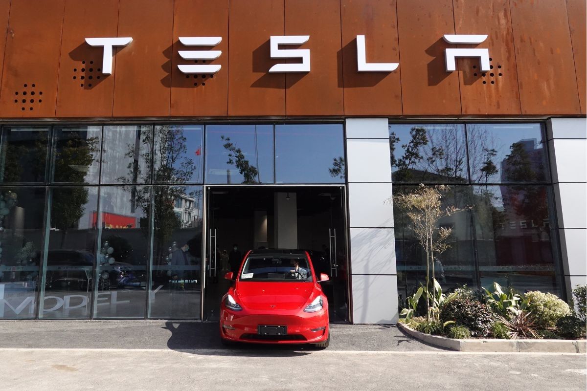 Tesla Model Y drives out of a Tesla dealership