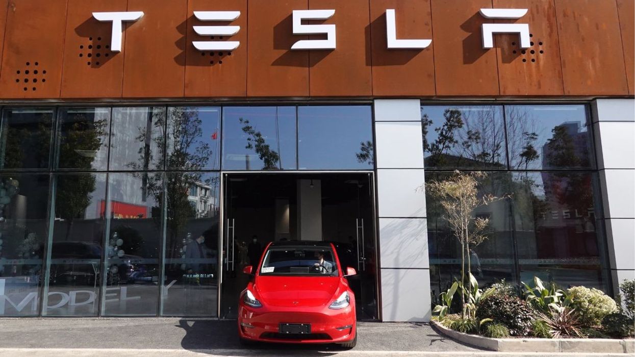 Tesla Model Y drives out of a Tesla dealership
