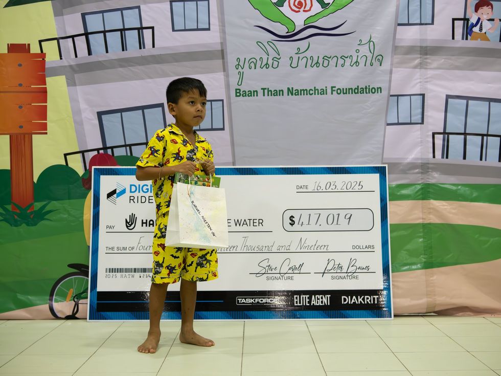 Thai child with cheque behind him