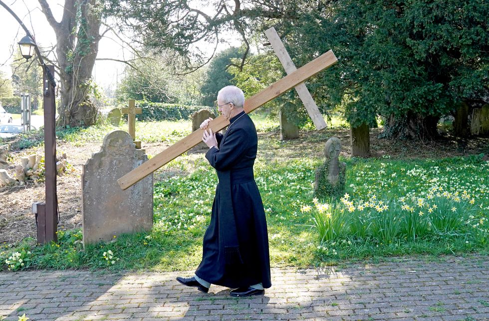 The Archbishop of Canterbury Justin Welby carries a wooden cross during the Walk of Witness at St Mary's Church, Sellindge, Kent, as he carries out his Holy Week engagements. Picture date: Friday April 15, 2022.