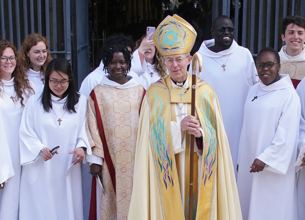 The Archbishop of Canterbury Justin Welby poses for a photograph with members of the Community of Saint Anselm as he leaves the Easter Sung Eucharist at Canterbury Cathedral in Kent. Picture date: Sunday April 17, 2022.