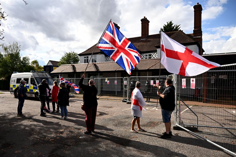The Bell Hotel in Epping with fencing around it, several protestors and a police presence