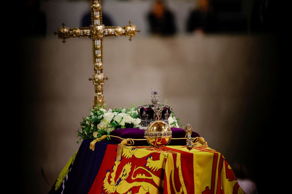 The coffin of Queen Elizabeth II, draped in the Royal Standard with the Imperial State Crown and the Sovereign's orb and sceptre, lying in state on the catafalque in Westminster Hall, at the Palace of Westminster, London. Picture date: Sunday September 18, 2022.