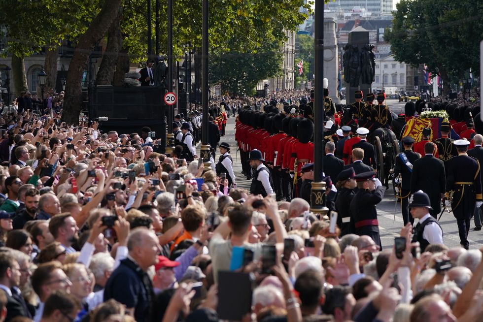 The coffin of Queen Elizabeth II, draped in the Royal Standard with the Imperial State Crown placed on top, is carried on a horse-drawn gun carriage of the King's Troop Royal Horse Artillery, during the ceremonial procession from Buckingham Palace to Westminster Hall, London, where it will lie in state ahead of her funeral on Monday. Picture date: Wednesday September 14, 2022.