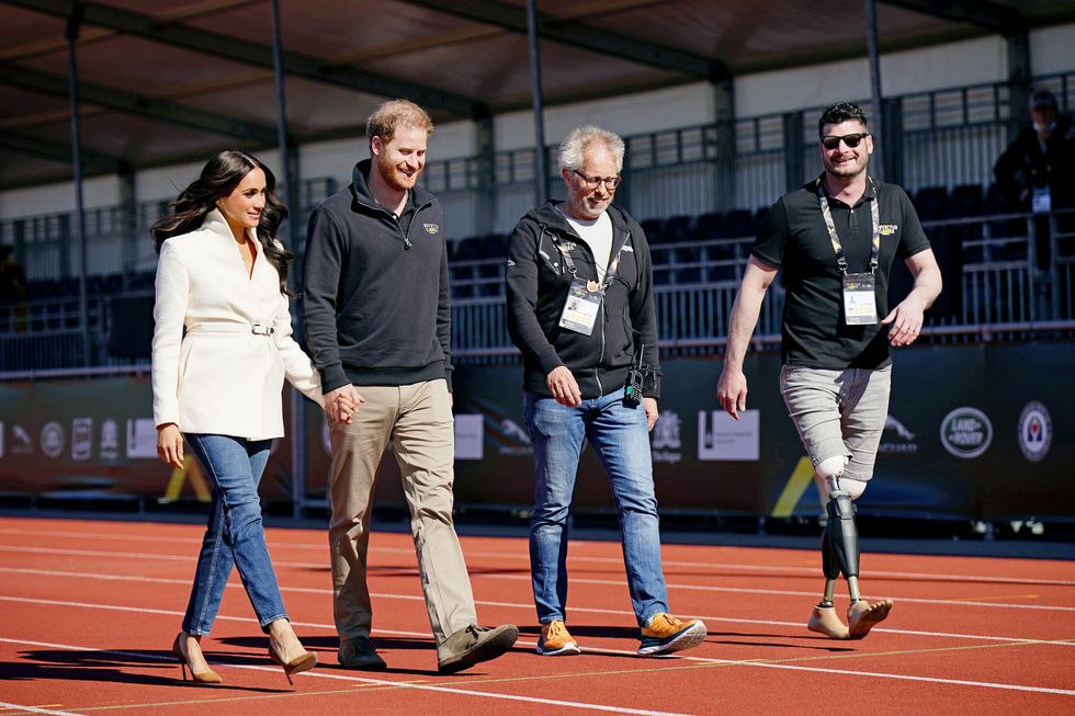 The Duke and Duchess of Sussex, with Invictus Games trustee and paralympian Dave Henson (right), attending the Invictus Games athletics events in the Athletics Park, at Zuiderpark the Hague, Netherlands. Picture date: Sunday April 17, 2022.