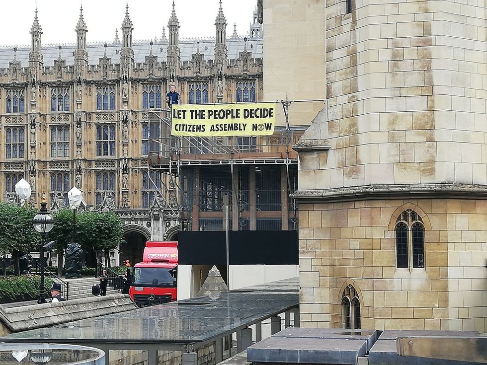 The eco-group unveiled a banner within Parliament's grounds.