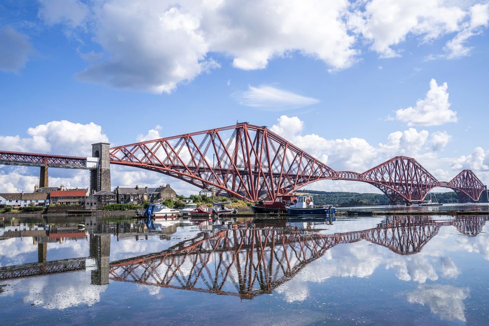 The Forth Bridge is reflected in North Queensferry Harbour, Fife. Picture date: Tuesday August 10, 2021.