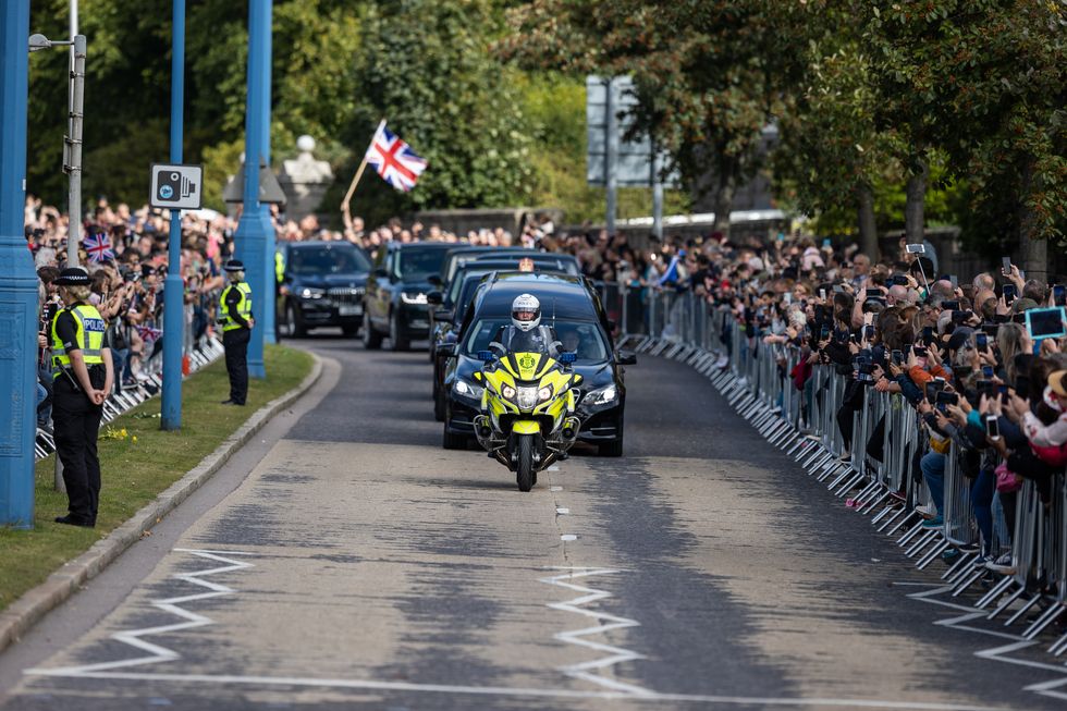 The hearse carrying the coffin of Queen Elizabeth II, draped with the Royal Standard of Scotland, passing through Aberdeen as it continues its journey to Edinburgh from Balmoral. Picture date: Sunday September 11, 2022.