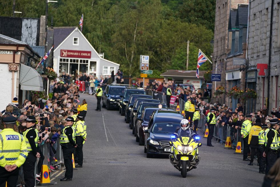 The hearse carrying the coffin of Queen Elizabeth II, draped with the Royal Standard of Scotland, passing through Ballater as it continues its journey to Edinburgh from Balmoral. Picture date: Sunday September 11, 2022.