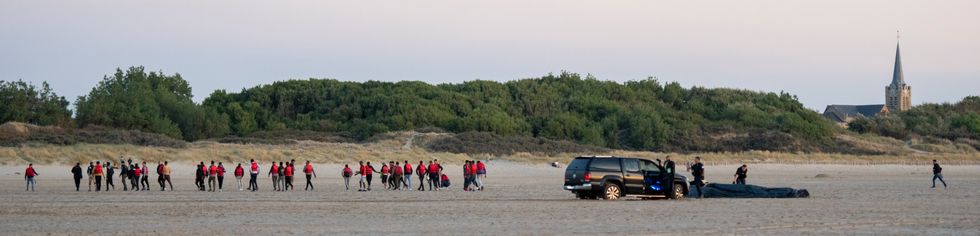 The migrants then returned back off the beach as police continued to deflate their boat