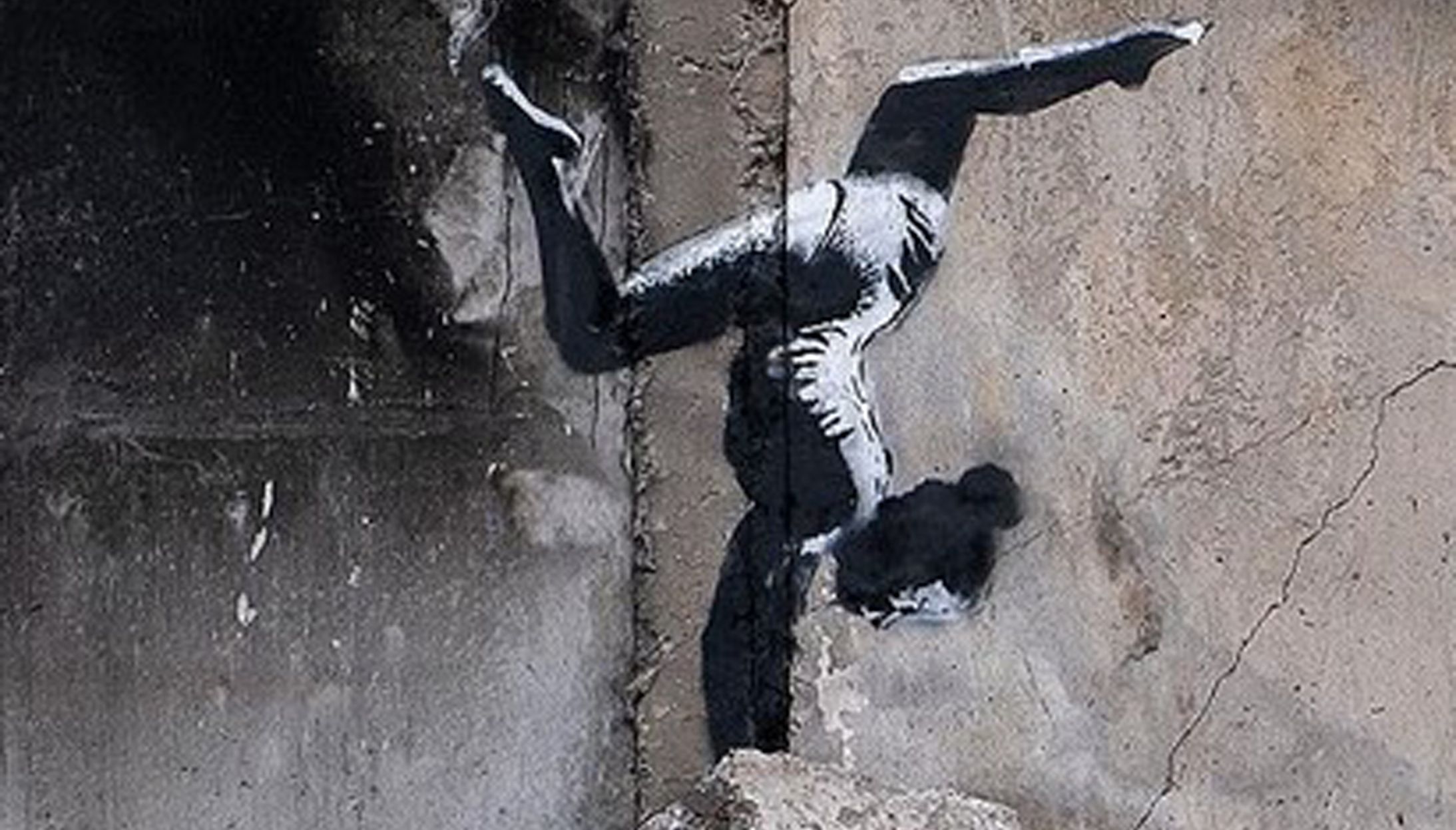 The mural is of a female gymnast balancing on a damaged building.