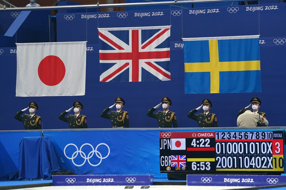 The national flags of Japan, United Kingdom and Sweden are raised ahead of the victory ceremony after the Women's Gold Medal Game during day sixteen of the Beijing 2022 Winter Olympic Games at the National Aquatics Centre in China.