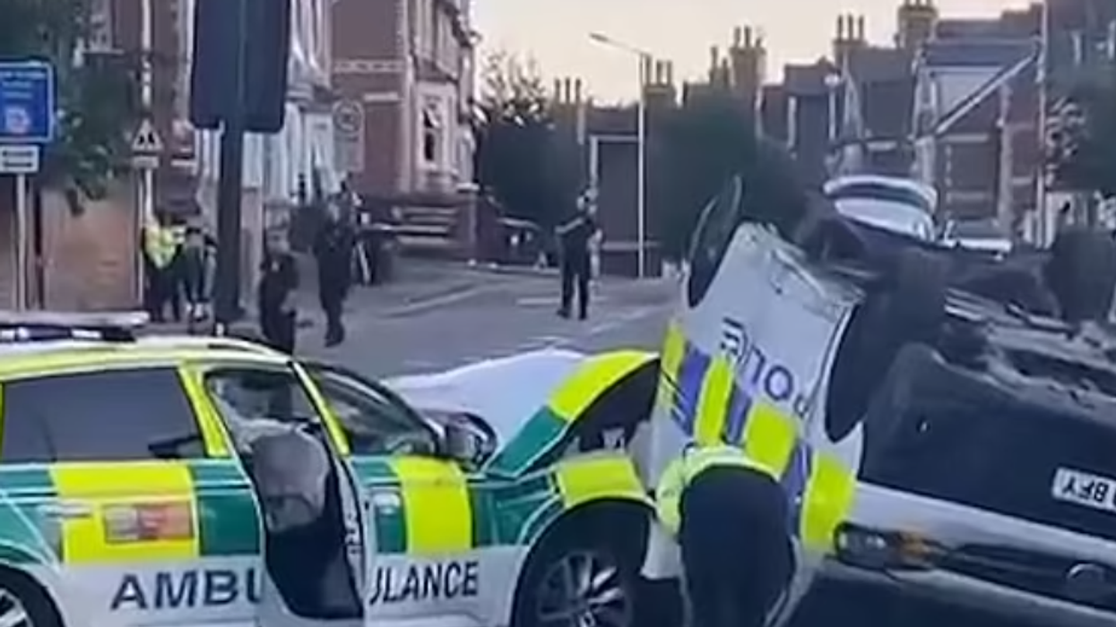 The overturned police van and the ambulance car next to it