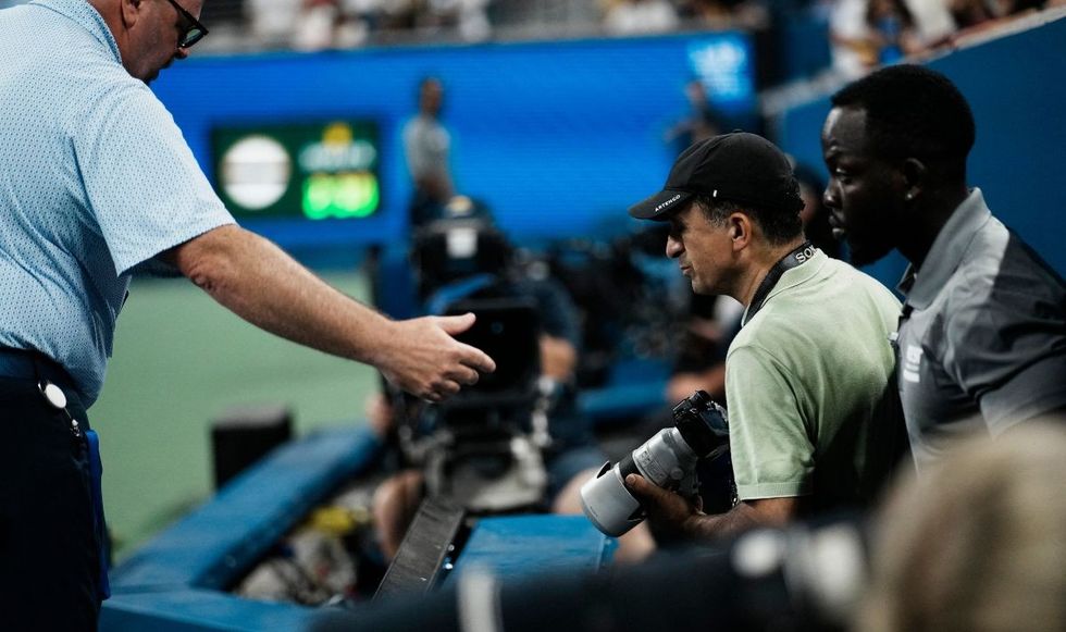The photographer at the centre of the row was escorted out of the stadium and has been banned from re-entering